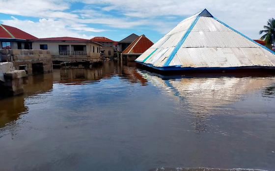 This photo released by National Emergency Management Agency shows a flooded street and partially submerged houses following a boat accident in Anambra Nigeria, Friday, Oct. 7, 2022. Seventy-six people are missing after a boat capsized in a flooded community in Nigeria's southeast Anambra state, emergency officials told the Associated Press on Monday. (National Emergency Management Agency via AP)