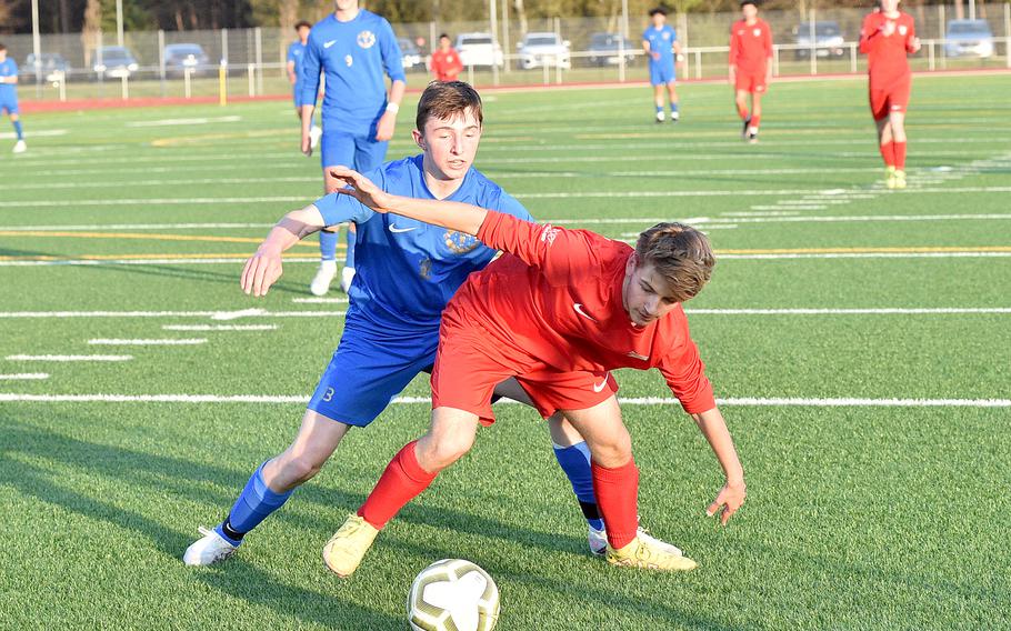 Kaiserslautern's Nikolai Engeman, right, holds off Ramstein's Kai Woodstock during Friday evening's match at Ramstein High School on Ramstein Air Base, Germany. The Royals defeated the Raiders, 6-1.