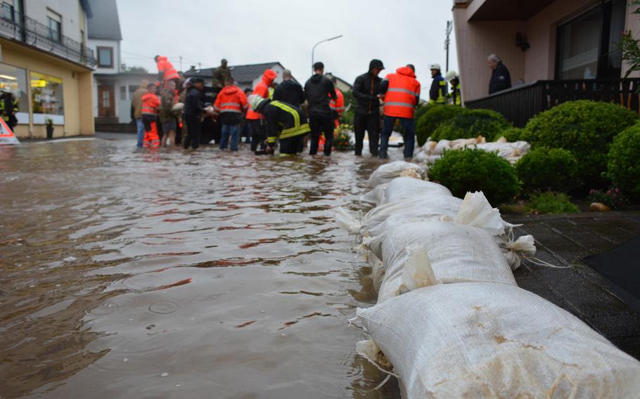 Members of Spangdahlem Air Base's 52nd Civil Engineering Squadron work with German first responders to fill and lay sandbags to prevent flooding in Binsfeld, Germany, July 14, 2021. About 20 military families at Spangdahlem were displaced by the floods and are being housed in temporary lodging on base.