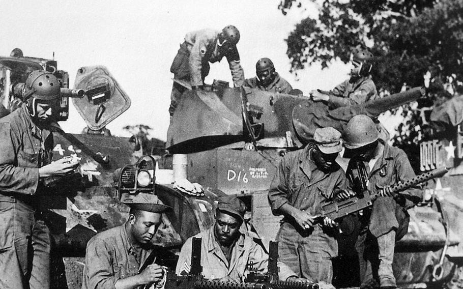 Soldiers from Dog Company of the 761st Tank Battalion check equipment before leaving England for combat in France in the fall of 1944.