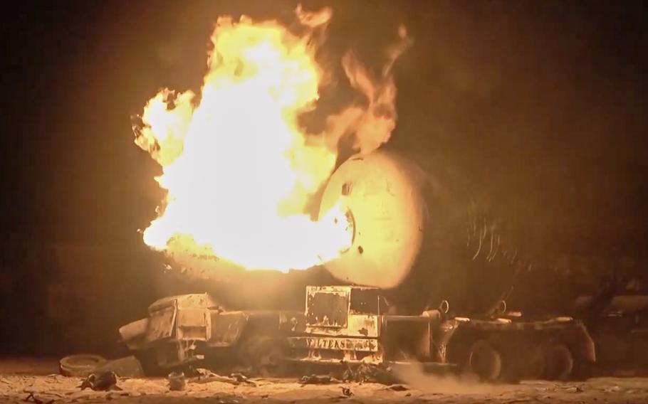 A video still frame of flames erupting from the back of a burning oil tanker.