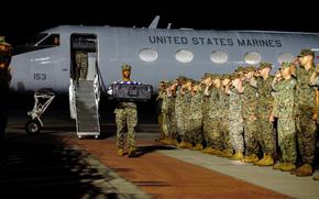 Marines saluting as remains are transported.