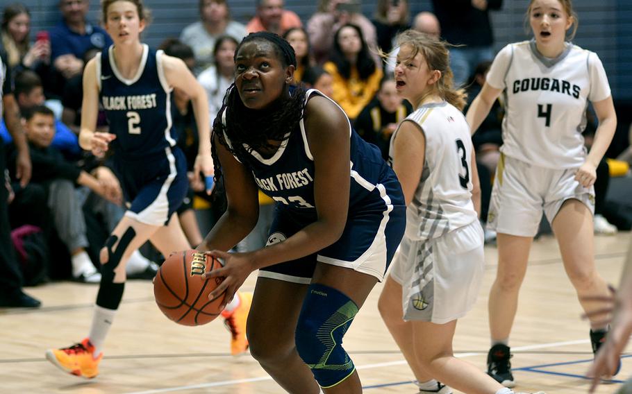 Black Forest Academy’s Olivia Kruse looks up to the basket while teammate Danielle Cherry and Vicenza’s Mackenzie Blue, center right, and Maya Fitch watch during pool play of the Division II DODEA Basketball Championships on Wednesday at Southside Fitness Center on Ramstein Air Base, Germany.