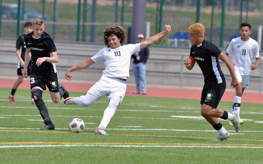 Ansbach’s Daeveon Brown takes a shot on goal against Alconbury’s Ian Barbour, left, and Taye Vickerstaff in the Cougars’ 1-0 win over Alconbury in the Division III boys title game at the DODEA-Europe soccer championships in Ramstein, Germany, May 22, 2025.