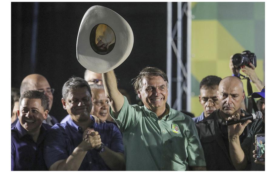 Brazilian President Jair Bolsonaro waves to his supporters during a campaign rally in Guarulhos, Brazil, on October 22, 2022. 