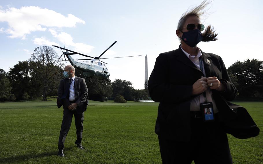 U.S. Secret Service agents stand guard as the Marine One helicopter, with former President Donald Trump on board, departs from the White House in Washington, D.C. for a campaign event in Duluth, Minnesota, on Sept. 30, 2020. 