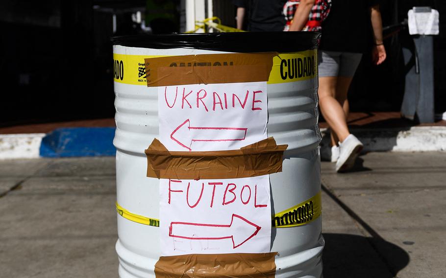Direction signs for soccer and for Ukrainians are taped on a barrel at the entrance to the Unidad Deportiva Benito Juárez along the border with the US in Tijuana, Baja California, Mexico, April 9, 2022.