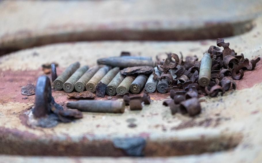 Six old bullets rest on top of a tank.
