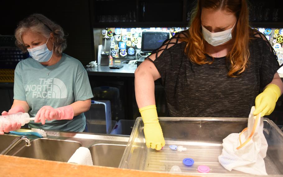 Volunteers Kimberly Barney, left, and Kara O’Neil clean bottles at the officers’ club at Ramstein Air Base, Germany, on Sept. 15, 2021. Volunteers have cleaned and sanitized more than 10,000 baby bottles for Afghan evacuees at Ramstein and Rhine Ordnance Barracks in less than a month.