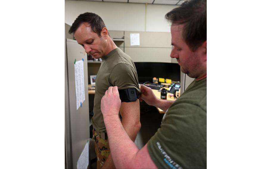 A man places an armband on an airman.