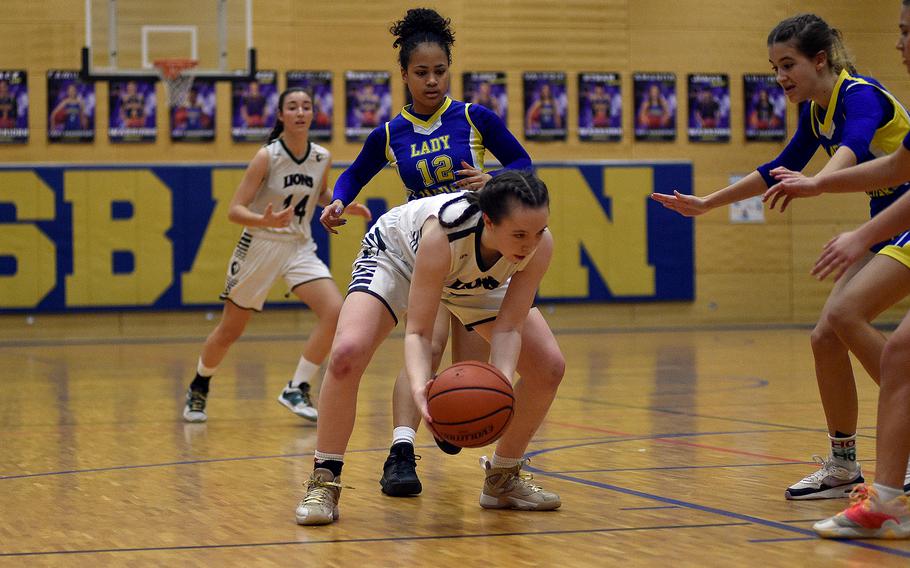 AFNORTH senior Isabella Guest goes low to pick up the ball while Sigonella freshman Alysia Dobbins defends during a Division III semifinal at the DODEA European Basketball Championships on Feb. 16, 2024, at Wiesbaden High School in Wiesbaden, Germany.