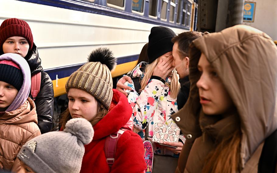 A man comforts his wife in Lviv, Ukraine, before she boards a train to Przemysl, Poland, on March 19, 2022.