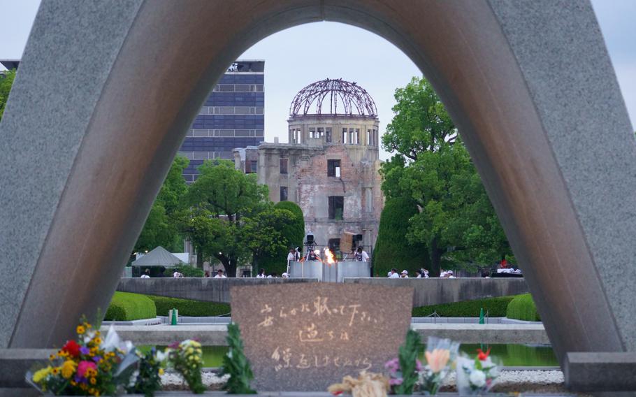 The Atomic Bomb Dome is seen through the Hiroshima Victims Memorial Cenotaph.