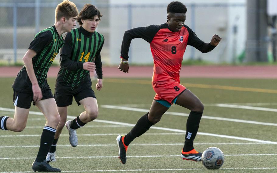 Nile C. Kinnick's Leon Awesso dribbles upfield with Robert D. Edgren's Ethan Wong and Luke Lehner in trail during Friday's DODEA-Japan boys soccer match. The Red Devils won 5-0.