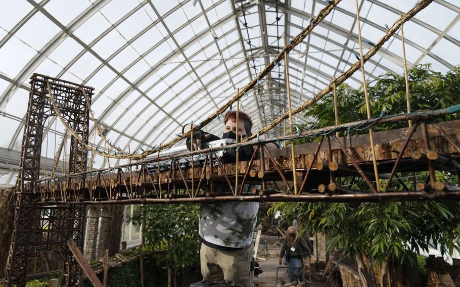 Kieran Beam works tracks on a bridge as part of the preparations for the annual Holiday Train Show at the New York Botanical Garden in New York, Thursday, Nov. 11, 2021. The show, which opens to the public next weekend, features model trains running through and around New York landmarks, recreated in miniature with natural materials. 