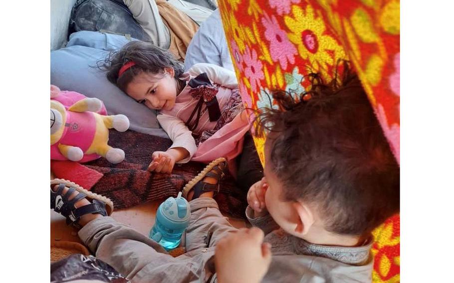 Maliha Asady, 7, waits with her younger brother Wafiullah, 2, at the Kabul airport in August 2021 before her family was turned away. Now in Rwanda, Maliha is part of the online Ivy and Bean book club. 
