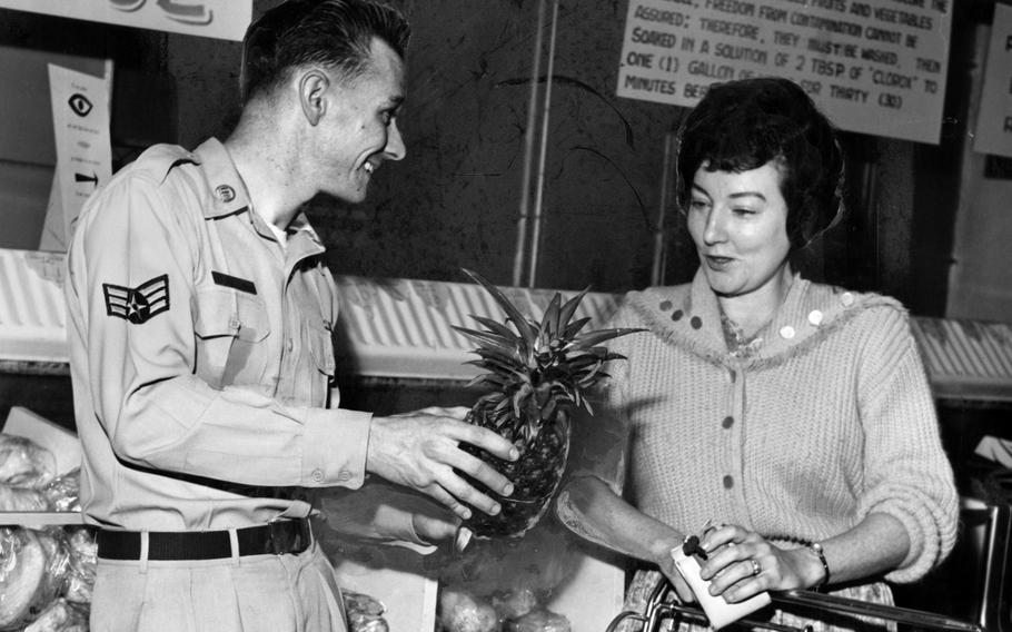 Green Park Housing Annex's commissary manager helps a shopper select a fresh pineapple in May 1962. Green Park, in western Tokyo, housed more than 2,000 people at a time between 1954 and 1973. 