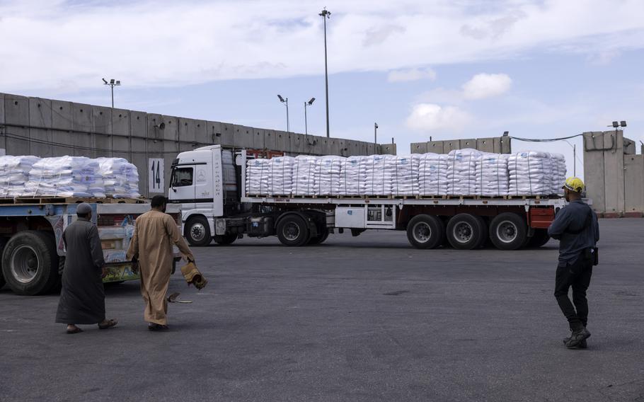 Egyptian drivers walk near their trucks that are loaded with humanitarian aid for Gaza at the Kerem Shalom border crossing on March 14, 2023. 