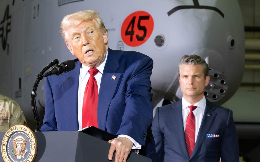 President Donald Trump speaks into a podium microphone, while Defense Secretary Pete Hegseth listens from behind him.