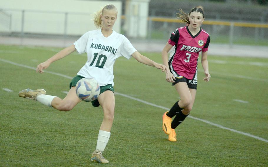 Kubasaki's Hailey Stoudemayer boots the ball against Kadena's Allie Sims during Wednesday's Okinawa girls soccer match. The Dragons won 1-0.