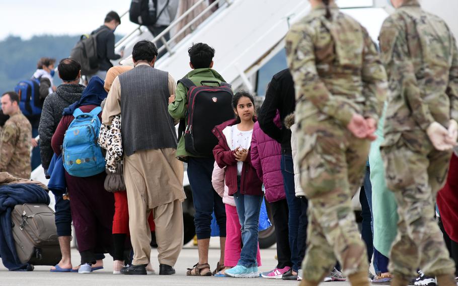 Airmen at Ramstein Air Base, Germany, watch as evacuees from Afghanistan board a commercial flight to the United States on Aug. 26, 2021. Two senators introduced legislation June 1, 2023, that would increase the number of visas available for people from Afghanistan who worked with the U.S. before the withdrawal of American forces in 2021.