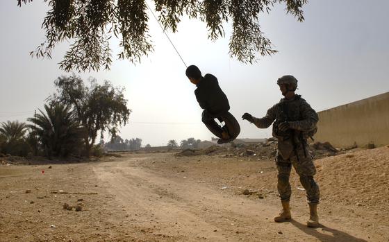 Eastern Babil Province, Iraq, Jan. 30, 2009: Sgt. 1st Class Brendon Hollingsworth, platoon sergeant for Troop E, 5th Calvary Regiment, gives an Iraqi boy a push on the tire swing he helped rig up Friday near a polling station in Eastern Babil Province, Iraq. 

META TAGS: Operation Iraqi Freedom, War on Terror, U.S. Army, 
