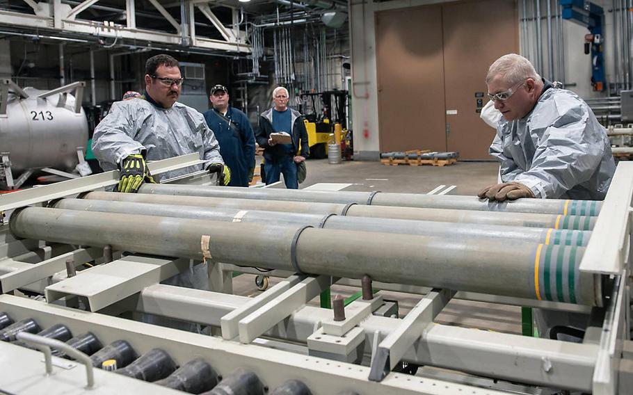 Blue Grass Chemical Agent-Destruction Pilot Plant operators place the first M55 rockets containing VX nerve agent on a conveyor to begin the destruction process July 9, 2021. 