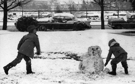 Washington Heights Dependent Housing Area, Tokyo, Japan, Feb. 3, 1963: Children get in some old-fashioned snow fun as the first real snow of the winter fell in Tokyo. Throwing one of his first snowballs is Bill Mullins, 9, and building a rather dingy snow man is his brother Ronald, 4. They are the sons of T/Sgt. K.W. Mullins, 6100th Support Sq., Tachikawa Air Base.

Looking for Stars and Stripes’ historic coverage? Subscribe to Stars and Stripes’ historic newspaper archive! We have digitized our 1948-1999 European and Pacific editions, as well as several of our WWII editions and made them available online through https://starsandstripes.newspaperarchive.com/

META TAGS: Pacific; Japan; military housing; military community; children; dependents; military family; weather; snow; winter;