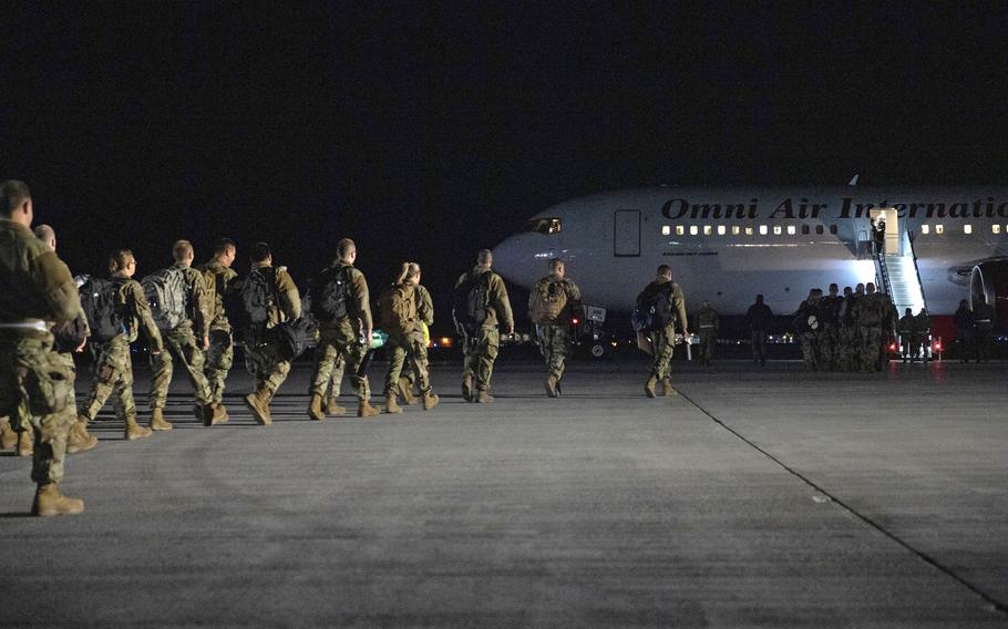 Airmen from the Vermont Air National Guard board a plane for a deployment to Europe near midnight from the Vermont Air National Guard Base, South Burlington, Vt., April 29, 2022. 