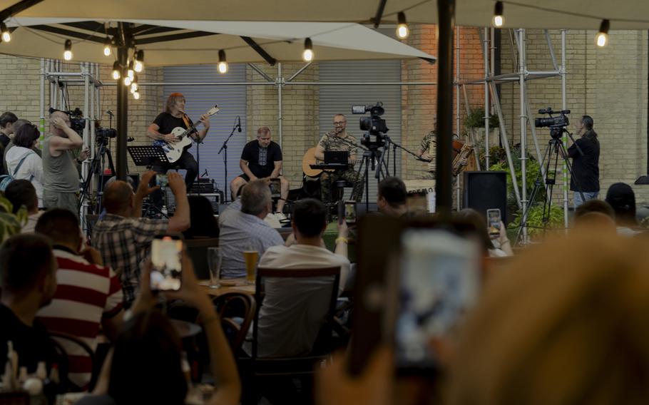 A concert given in Kyiv on July 13 by Taras Borovok, seated onstage right with guitar. The musician also is a soldier and is famous for his song “Bayraktar,” which celebrates the Turkish attack drone of the same name. 