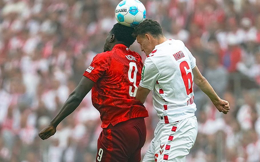 Two soccer players try to head the ball.