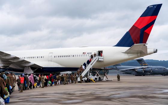 Airmen assigned to the 721st Aerial Port Squadron form a gate as evacuees from Afghanistan board a Delta Airlines flight at Ramstein Air Base, Germany, Aug. 30, 2021. An official at Ramstein Air Base said flights carrying Afghan refugees from Germany to the U.S. are expected to resume over the Columbus Day weekend, following a weekslong pause imposed after measles cases were detected in several evacuees. 

