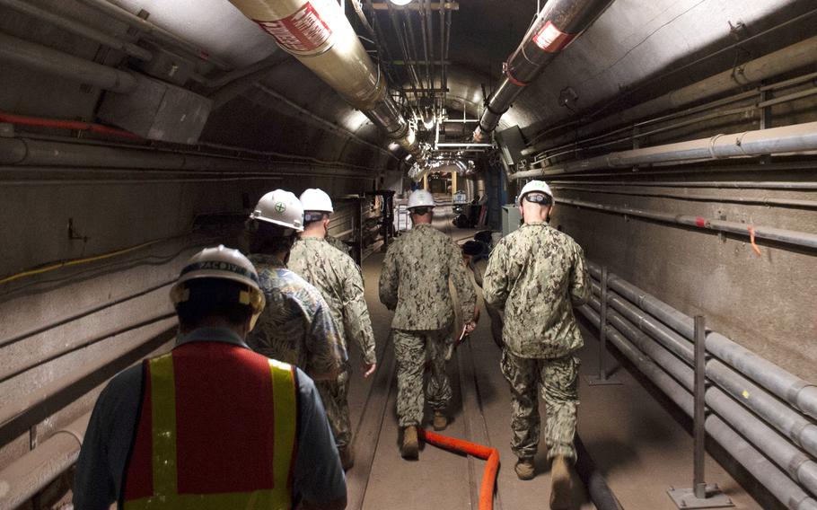 In this Dec. 23, 2021, photo provided by the U.S. Navy, Rear Adm. John Korka, Commander, Naval Facilities Engineering Systems Command (NAVFAC), and Chief of Civil Engineers, leads Navy and civilian water quality recovery experts through the tunnels of the Red Hill Bulk Fuel Storage Facility, near Pearl Harbor, Hawaii.