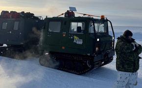 A vehicle is seen on snowy terrain.