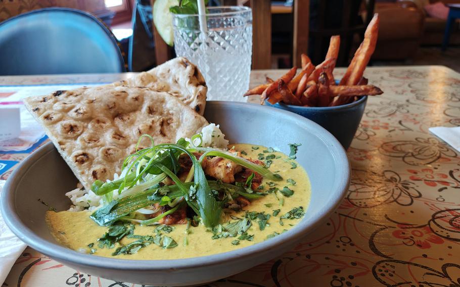 A plate of coconut curry  sits on a table at Portro Lounge.