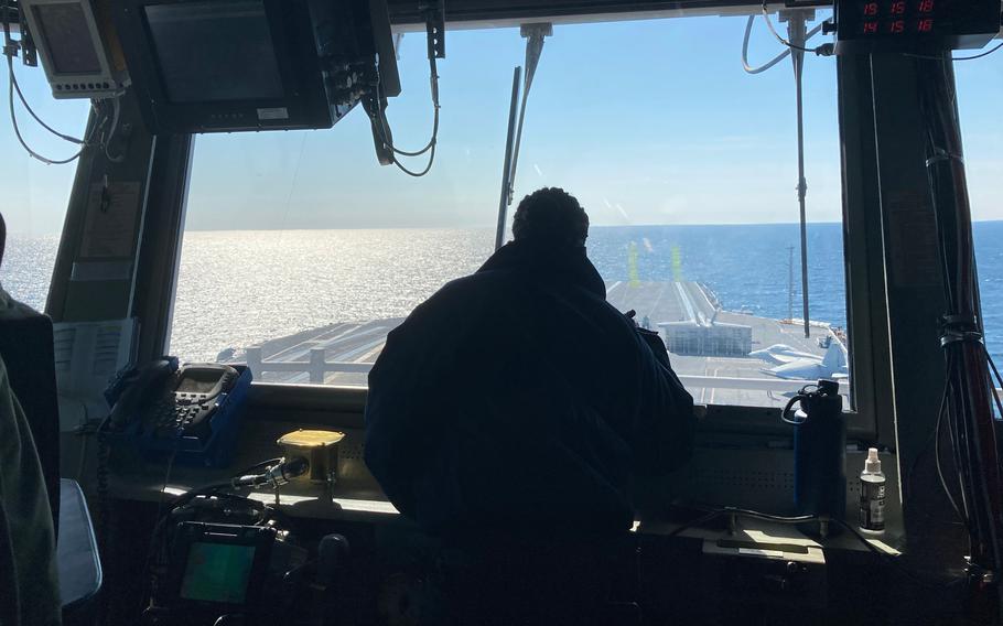 High up on USS Gerald R. Ford's island, controllers in the carrier's primary flight control are just some of the dozens of eyes watching for hazards as pilots take off and land every minute or so, working on their carrier qualifications.