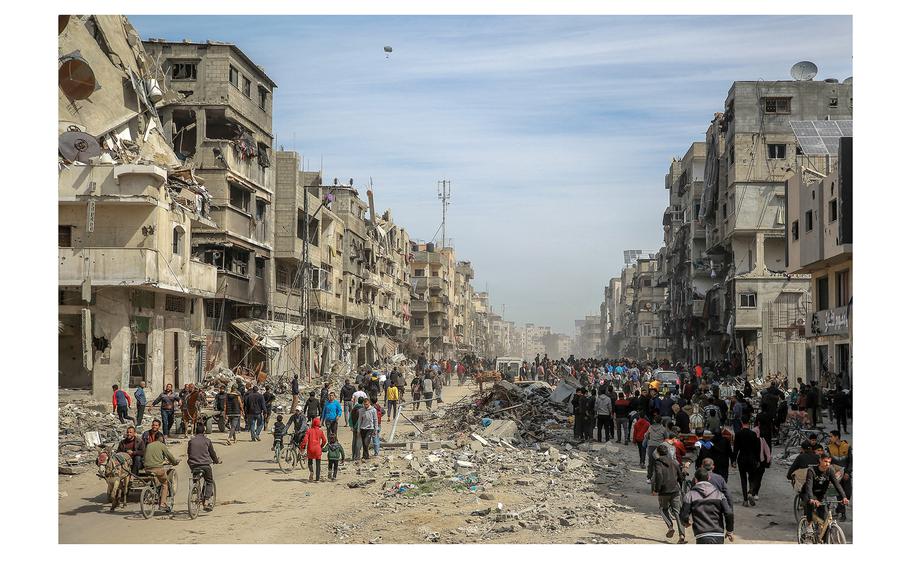 Palestinians gather in a street as humanitarian aid is airdropped in Gaza City on March 1, 2024, amid the ongoing conflict between Israel and the Hamas militant group. 