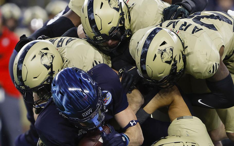 Navy fullback Alex Tecza is gang tackled by Army defenders during the second quarter of an NCAA football game at Gillette Stadium Saturday, Dec. 9, 2023, in Foxborough, Mass. 