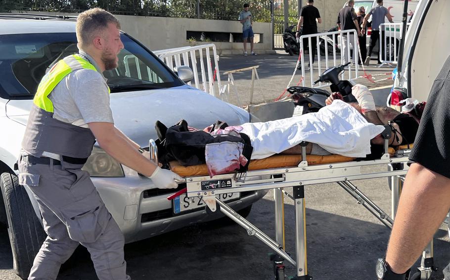 An emergency worker moves a stretcher carrying a wounded man.