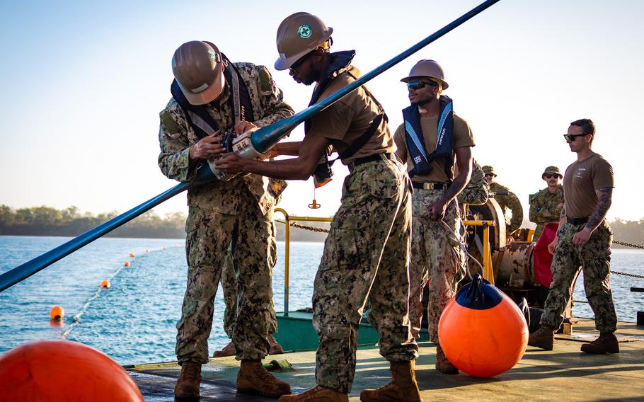 U.S. sailors assigned to Amphibious Construction Battalion 1 work to affix a buoy connector aboard an Australian vessel during a ship-to-shore fuel pipeline exercise in Weipa, Australia, July 21, 2023. The event was part of Talisman Sabre.