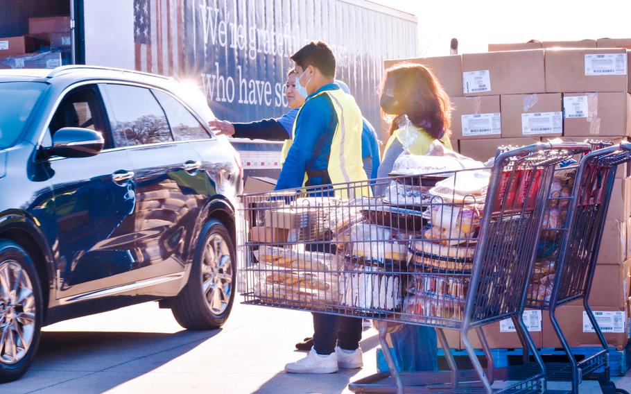 Volunteers prepare to load a vehicle at a Military Family Advisory Network food distribution event for Fort Hood military families in Killeen, Texas, on March 19, 2022. 