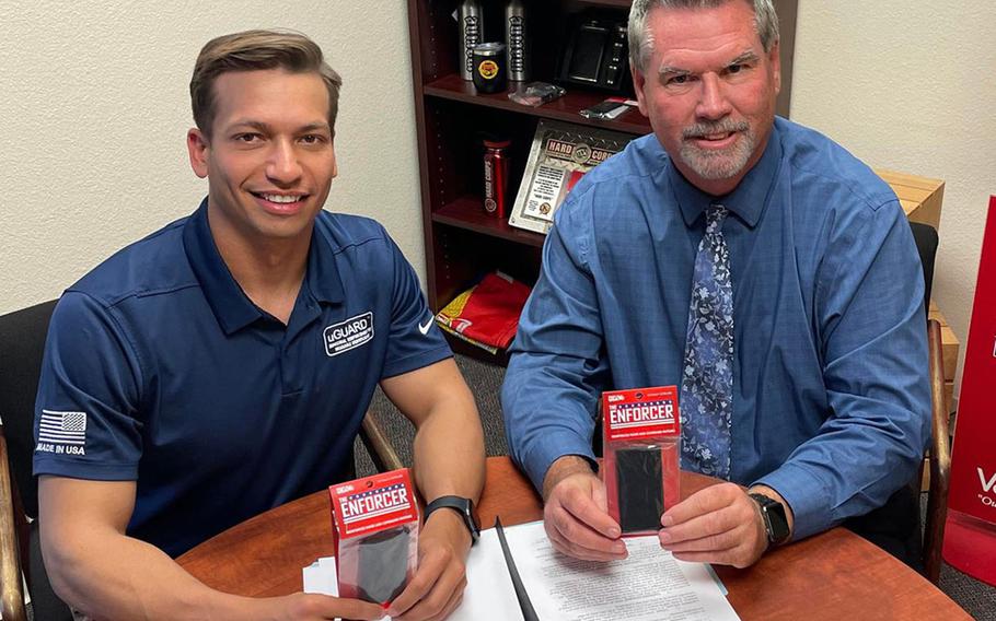 Navy Lt. Mitchell Kempisty, inventer of The Enforcer name tag protector, poses with Michael Harrison, chief operating officer of Vanguard, which is marketing the sailor's design. 