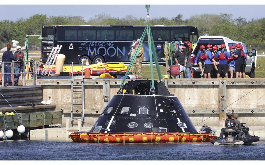 Members of NASA’s Orion crew recovery team gather as the test capsule is hoisted out of the water during training for the Artemis II mission at Kennedy Space Center, Florida, Launch Complex 39, on Monday, Feb. 6, 2023. The team practices recovery exercises using the capsule – called a Crew Module Test Article – which will be sent to San Diego for further training ahead of the planned 2024 launch of the Artemis II crewed mission to the moon.