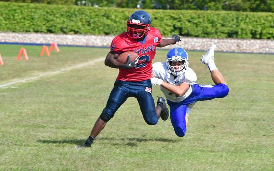 Aviano's JuJu Las Salles, who rushed for more than 100 yards, breaks a tackle to score the first of three touchdowns during the Saints' 44-0 victory over the Rota Admirals on Saturday, Sept. 23, 2023. 
