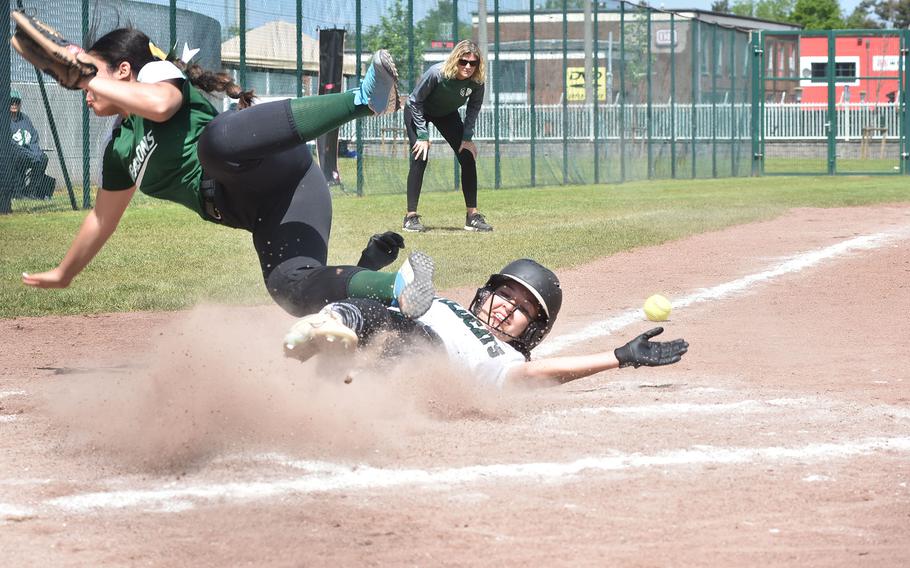 Alconbury pitcher Alondra Acosts goes flying over a sliding Kapriana Martinez from Naples in the DODEA-Europe Division II/III softball championships at Kaiserslautern, Germany.