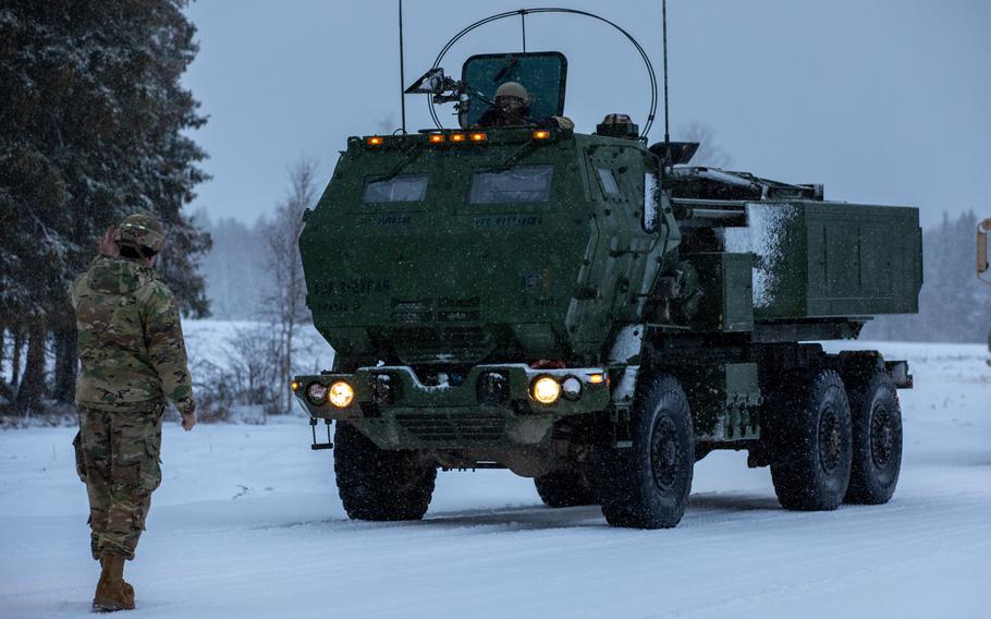 A U.S. Army soldier assigned to Task Force Voit, 3rd Battalion, 27th Field Artillery Regiment, 18th Field Artillery Brigade, 18th Airborne Corps, guides an M142 High-Mobility Artillery Rocket System (HIMARS) launcher into place to demonstrate HIMARS capabilities to multinational troops from NATO’s enhanced Forward Presence Battle Group Estonia at the Central Training Area​​ near Camp Tapa, Estonia, Dec. 22, 2023. 