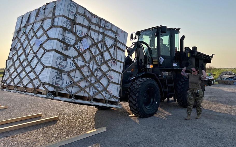 Senior Airman Hunter Evans, driving the forklift, and other airmen from the 387th Air Expeditionary Squadron move humanitarian supplies from a C-130 at Sukkur Airport in Pakistan on Sept. 9, 2022.
