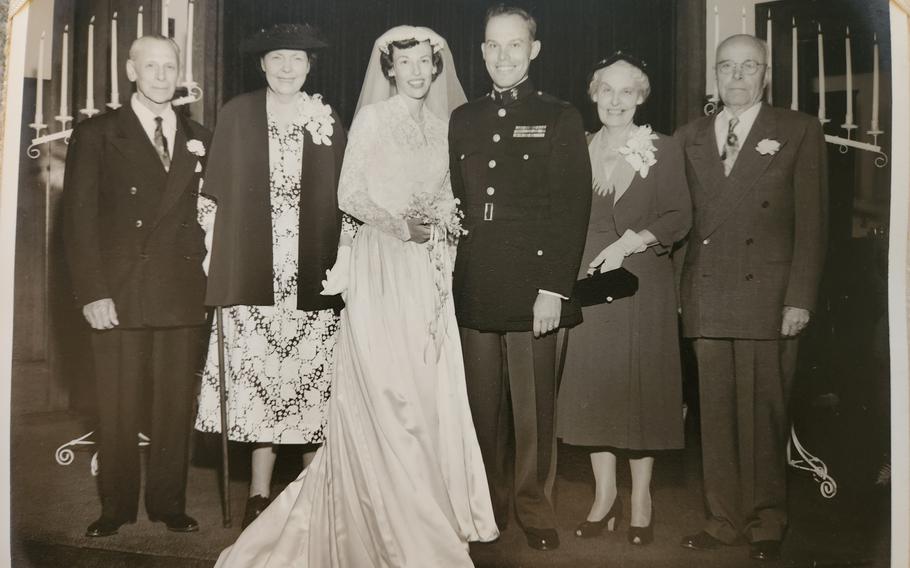 A family poses for a picture with a bride and groom after a wedding.