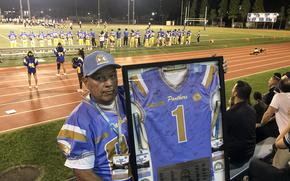 William Lee holds a framed Panthers football jersey during the homecoming game at Yokota Air Base, Japan, Friday, Sept. 29, 2023. It was signed by Lee and fellow alumni who returned to celebrate Yokota High's 50th anniversary.