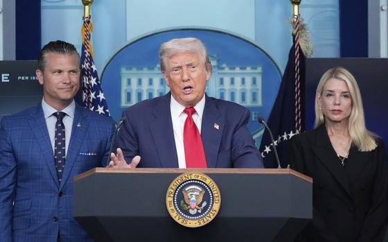 Trump speaks at a microphone, with Hegseth and Bondi flanking him.